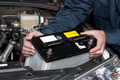 Auto mechanic replacing car battery Auto mechanic replacing car battery